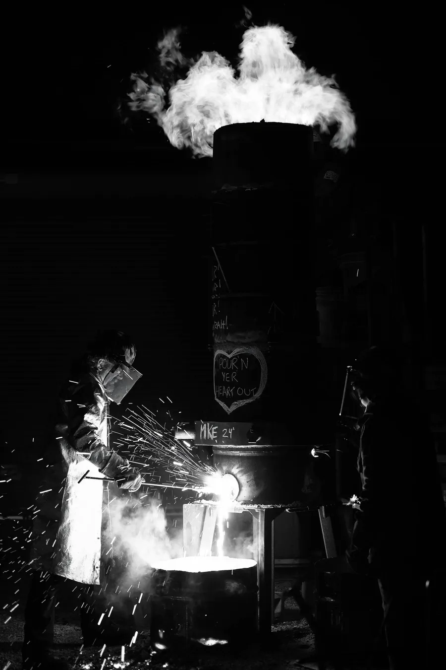 Blacksmith shaping iron with a hammer, at night