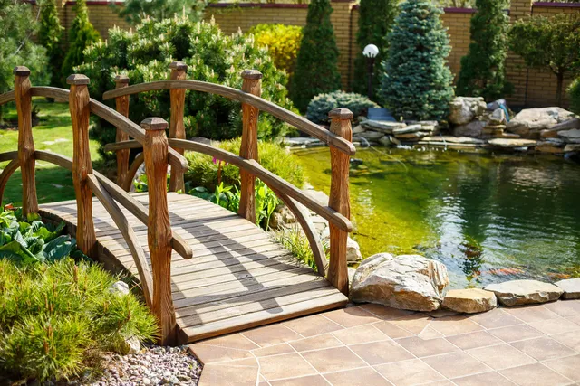 Pont de jardin en bois au-dessus d’un bassin à koï